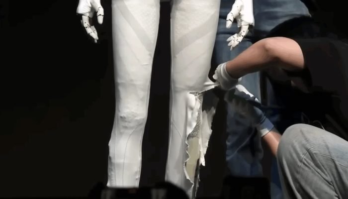 Engenheiros da XPeng abrem o robô IRON ao vivo durante conferência da empresa. (Imagem: Reprodu...